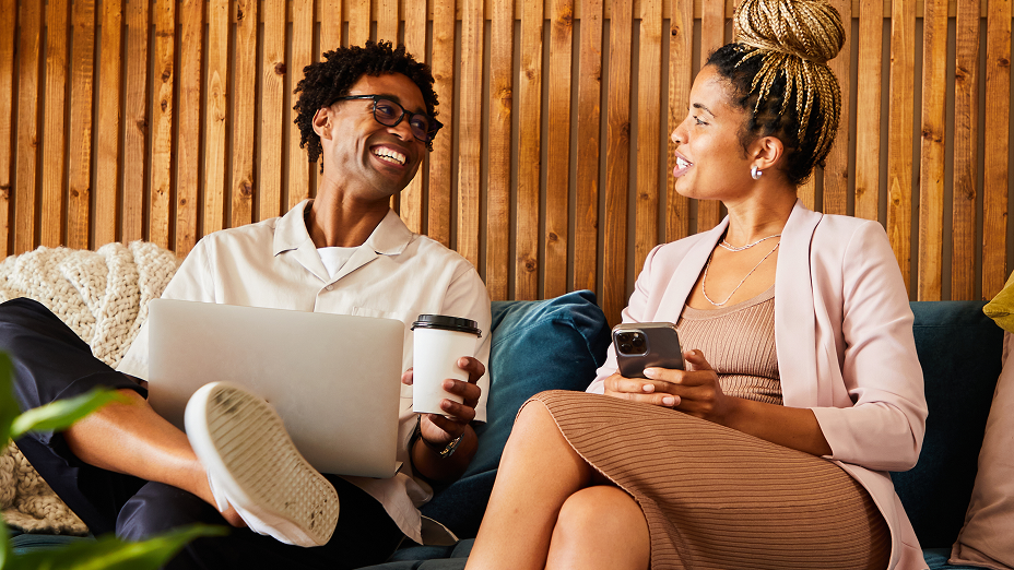 Two people on a couch smiling and looking at each other, representing the positive human connections fostered through social media